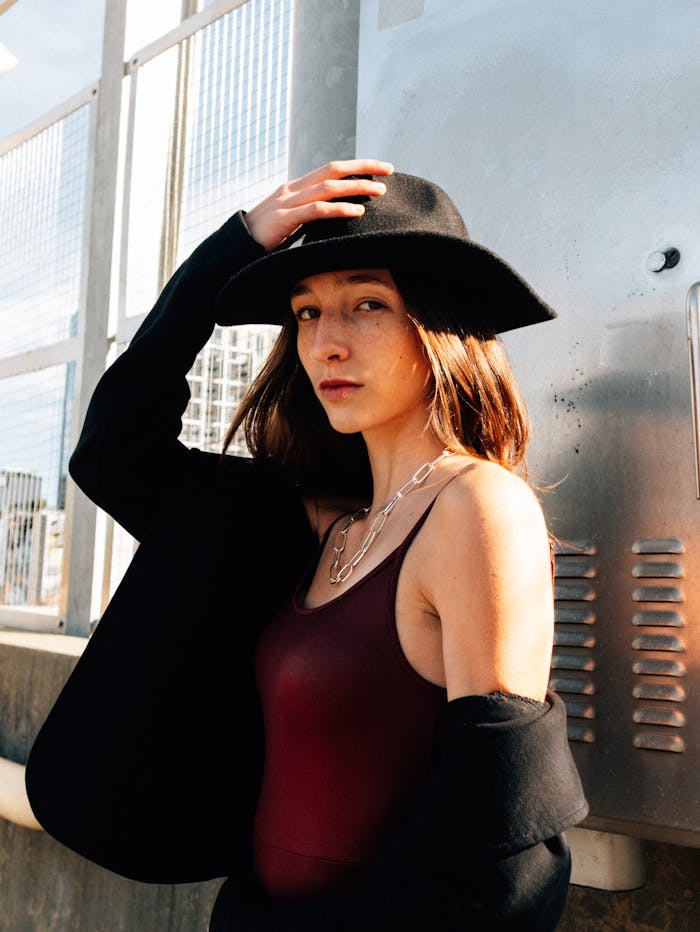 Fashion portrait of a woman in a black hat and blazer posing in Atlanta, showcasing urban style.